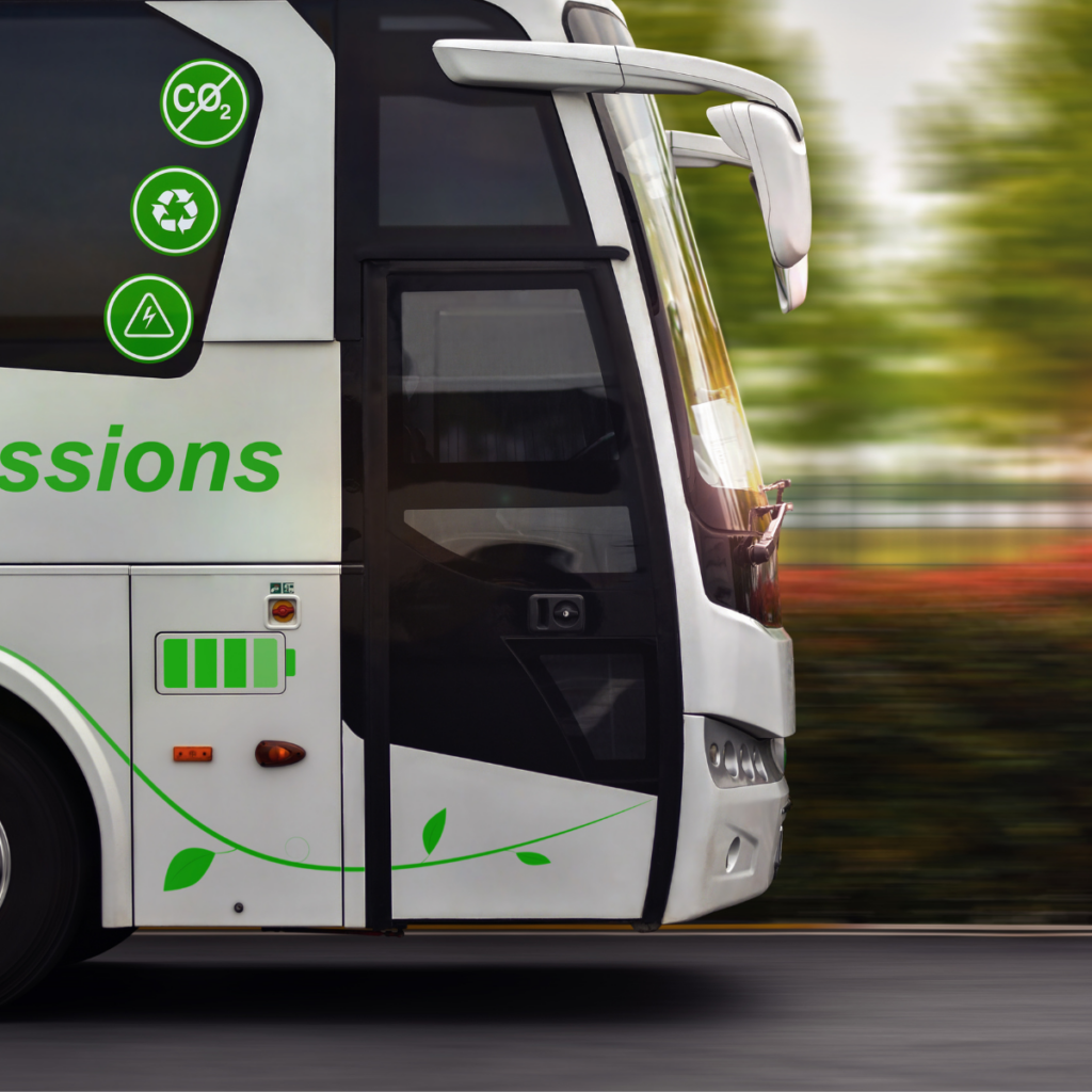 The front of a white coach in motion, with green leaf graphics, a battery gauge and CO2, recycling and charging icons on its side